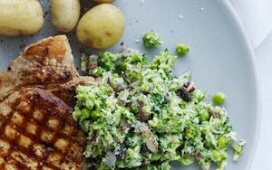 Broccolicouscous med ærter og rødløg, serveret med svinekotelet og nye kartofler