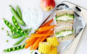 Sandwich til madpakken med snacks dertil som gulerødder, majs og ærter